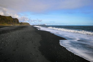 Vik, Güney İzlanda dalga ve deniz köpük ile siyah kum plaj.