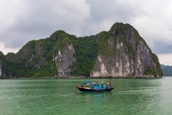 Vietnamca geleneksel mavi balıkçı teknesi, Unesco Dünya doğal mirası, Vietnam ile Halong bay kireçtaşı oluşumları.