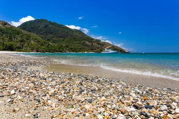 Plage d'Aninuan, Puerto Galera, Mindoro Oriental aux Philippines, vue sur le paysage avec des galets et des coquillages au premier plan . — Photo