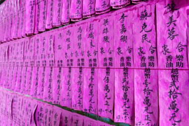 Pembe kağıt dua bayrakları veya dua chi Cho Lon Thien Hau Tapınağı (Chinatown), ilçe 5, Saygon, Ho Chi Minh City, Vietnam Çin siyah mürekkep isimleri ile kayar.