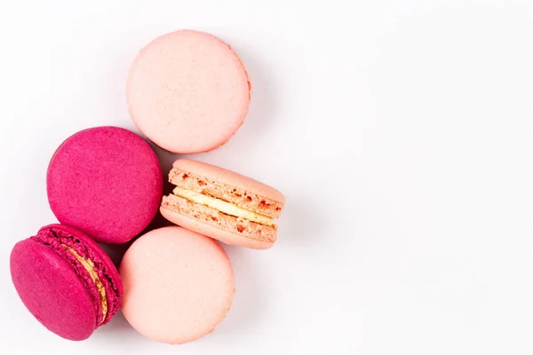 French pink and magenta macarons or macaroons, top view on a white background with copyspace. — Stock Photo, Image