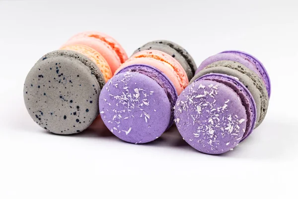 French purple, grey and pink macarons or macaroons, aligned in closeup side view. — Stock Photo, Image