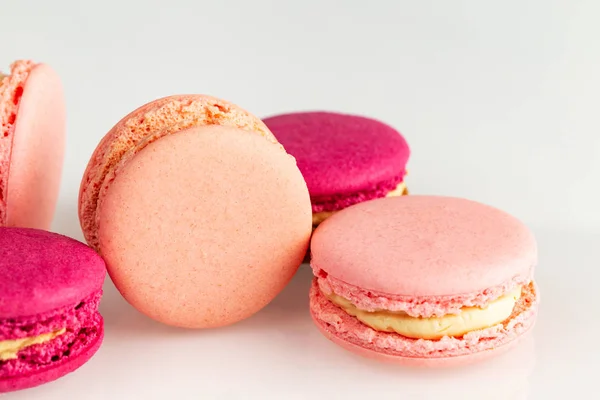 French pink macarons or macaroons, closeup, side top view on a white background. — Stock Photo, Image
