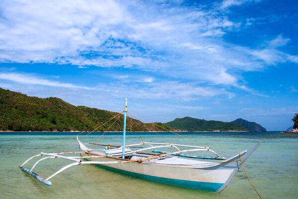 Banca boat on the beach of Vigan island (snake Island) in El nido region of Palawan in the Philippines.