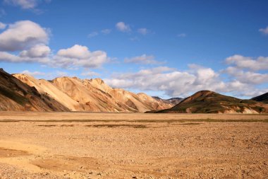 Landmannalaugar Ulusal Parkı'nda gün batımında turuncu ve yeşil dağlar, İzlanda.