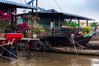 Kağıt çiçekler, orkide ve Tet Yeni Yıl Kutlaması, Mekong Delta, Vietnam için sarı çiçekler ile House tekneler.