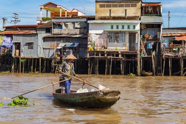 Donna irriconoscibile che indossa il tradizionale cappello conico vietnamita a remi su una barca presso le case di Can Tho, Delta del Mekong, Vietnam . — Foto Stock