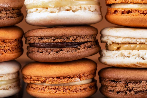 Piles of brown and white french macarons or macaroons, (chocolate, coffee, toffee, salted caramel and vanilla). — Stock Photo, Image