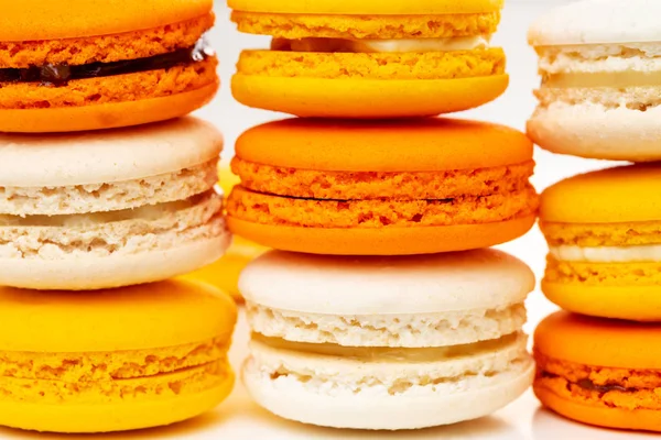 Orange and yellow macarons or macaroons stacked or piled. Closeup. — Stock Photo, Image