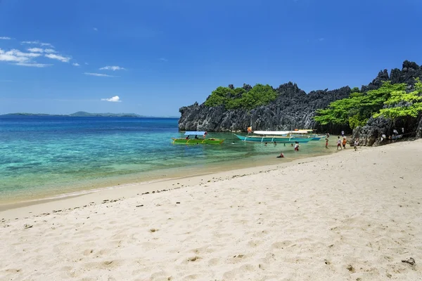 Personnes méconnaissables jouant par les bateaux Banca sur la plage de l'île de Lahus, Caramoan, province de Camarines Sur, Luçon aux Philippines . — Photo