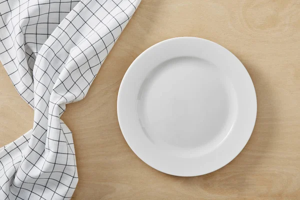 Textil cell servett på träbord med kopia utrymme och vit tom platta — Stockfoto