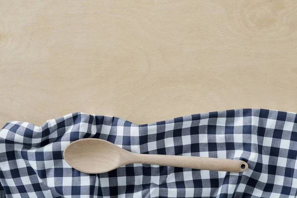 Cuchara de madera con servilleta textil azul sobre mesa de madera con espacio para copiar — Foto de Stock