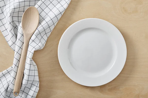 Textilzellenserviette auf Holztisch mit Kopierraum und weißem leeren Teller — Stockfoto
