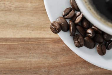 Bir fincan kahve beyaz fasulye kopya alanı ile ahşap masa üzerinde. Üstten görünüm.