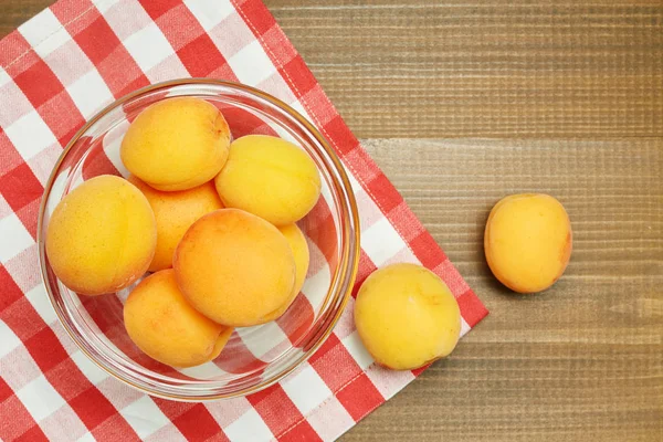 Reife Bio-Aprikosen mit Blättern auf einem Farbtisch. Zutaten zum Kochen. — Stockfoto