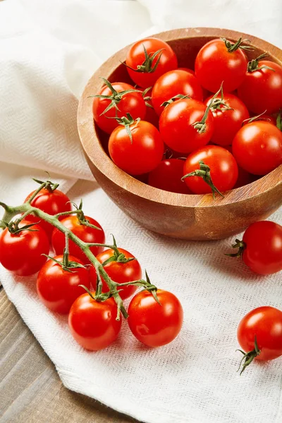 Tomates cereja vermelhos frescos em tigela sobre fundo de madeira com guardanapo têxtil. Ingredientes para cozinhar . — Fotografia de Stock