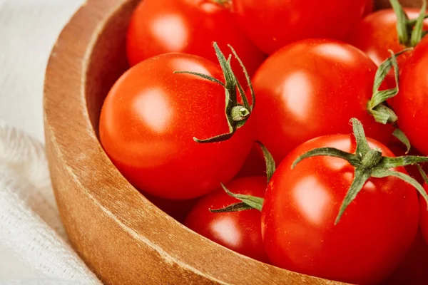 Tomates cereja vermelhos frescos em tigela sobre fundo de madeira com guardanapo têxtil. Ingredientes para cozinhar . — Fotografia de Stock