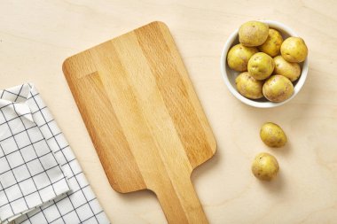 Çiğ patates Doğrama Kurulu ve tekstil peçete ile masada. 