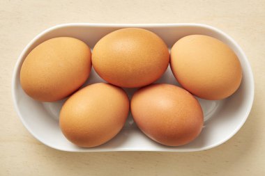 Ahşap masa üstünde tüm çiğ yumurta. 