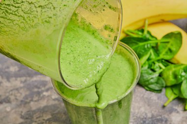 Ispanaklı bir karıştırıcıda muz. Smoothie hazırlık süreci.