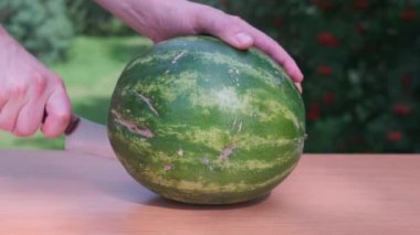 Birisi adam kesilmiş arasında Ripe karpuz lezzetli sulu karpuz üzerinde tablo.