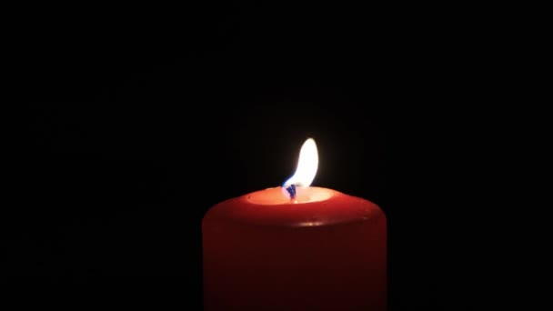 Spalanie czerwona świeca na czarnym tle. — Wideo stockowe
