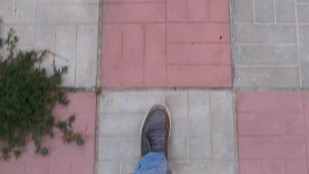 Person går på kakel golvet på gatan på en solig dag. — Stockvideo