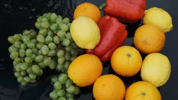 Filmación en cámara lenta naranja, limón, uva, pimiento rojo con salpicaduras y gota de agua . — Vídeos de Stock