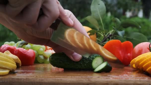 Pepino de corte manual con un cuchillo en tabla de madera . — Vídeos de Stock