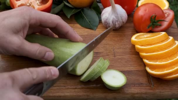 Person hands cutting zucchini on cutting wooden board. — Stock Video