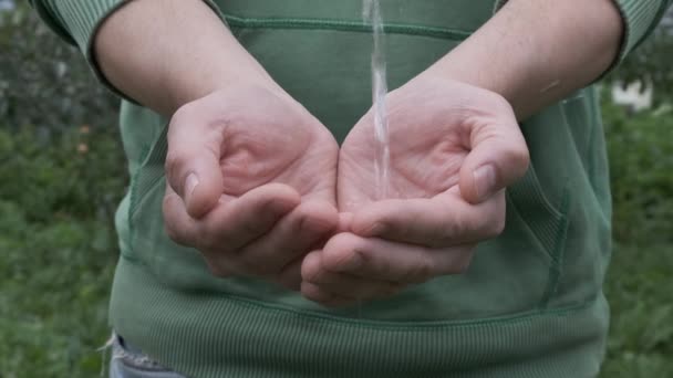 Woda nalewanie pod ręką na naturalnym tle. — Wideo stockowe
