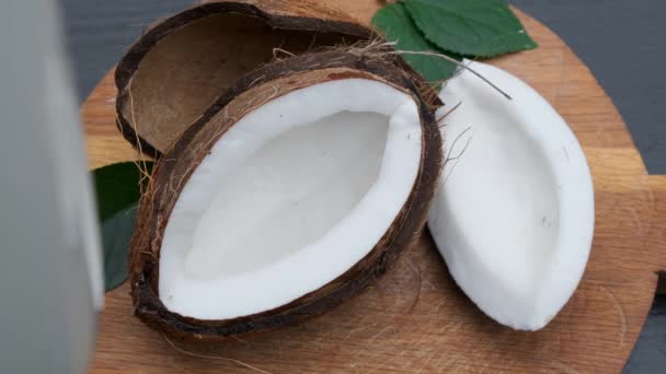 Nalévání čerstvého kokosového mléka na dřevěný stůl. — Stock video
