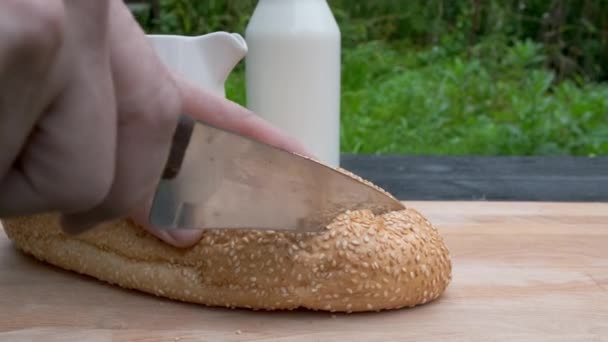 Homem cortando pão em cortar tábua de madeira . — Vídeo de Stock