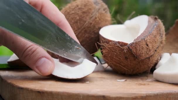 Hand med knivskivor av trasig tropisk kokosnöt. — Stockvideo