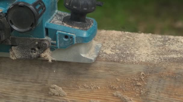 Worker planing electric planer piece of wood. — Stock Video