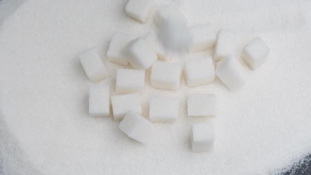 Cubos de açúcar branco caem sobre granulado . — Vídeo de Stock
