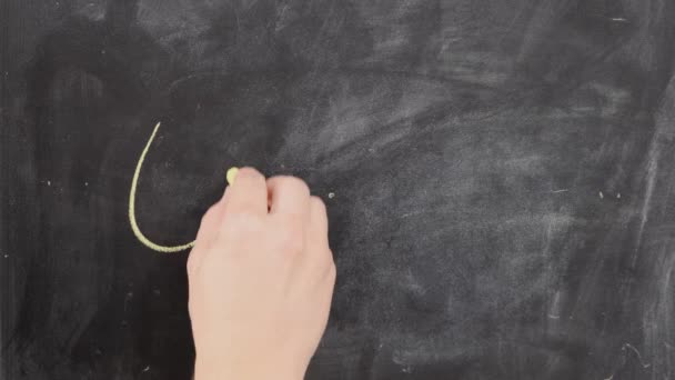 Die weibliche Hand schreibt das Wort mit Kreide auf schwarze Tafel. — Stockvideo