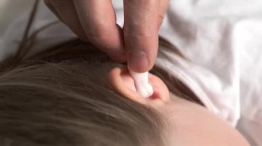 Beyaz pamuklu çubukla hasta kulak tak..