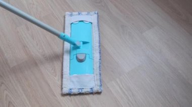 Evde ıslak paspas ile ahşap zemin laminat temizliği.