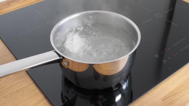 Chicken eggs boiling in stainless steel pan in water. — Stock Video