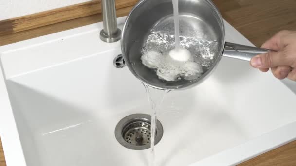 Raffreddare una pentola e un uovo pieno di uova sode sotto l'acqua corrente del rubinetto . — Video Stock