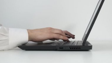 Ofiste dizüstü bilgisayar klavyesinde el yazma. Beyaz tablo.