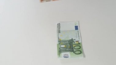 İşadamı elleri beyaz masaya euro banknot koydu.