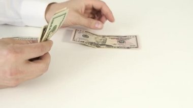 Beyaz masadaki banknotları sayan bir iş adamı.