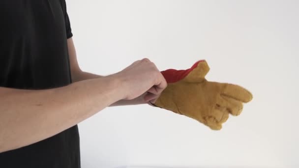 Un homme porte des gants sur un fond blanc . — Video