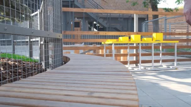 Man in blue jeans sitting down wooden bench. — Stock Video