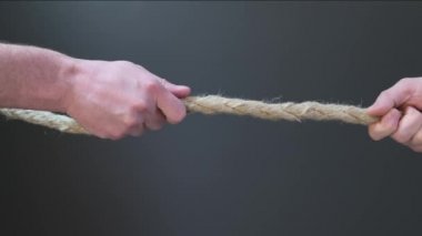 İki elinle siyah arka planda ipi çek