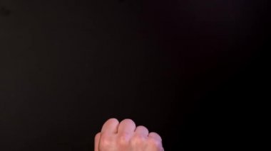 Adam siyah arka planda orta parmağını gösteriyor. Kapat.