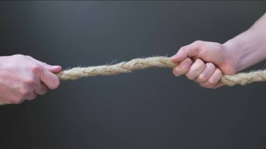 İki elinle siyah arka planda ipi çek