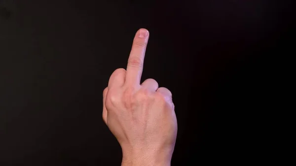 Man shows middle finger on black background. Close up — Stock Photo, Image